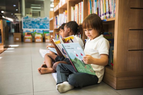 menino lendo livro na escola