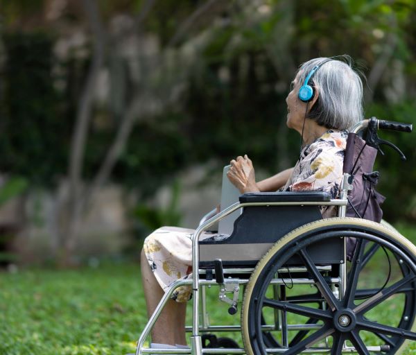 Demência senil - idosa em cadeira de rodas fazendo tratamento com musicoterapia.