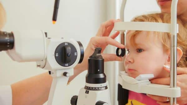 Criança pequena realizando exames oftalmológicos.